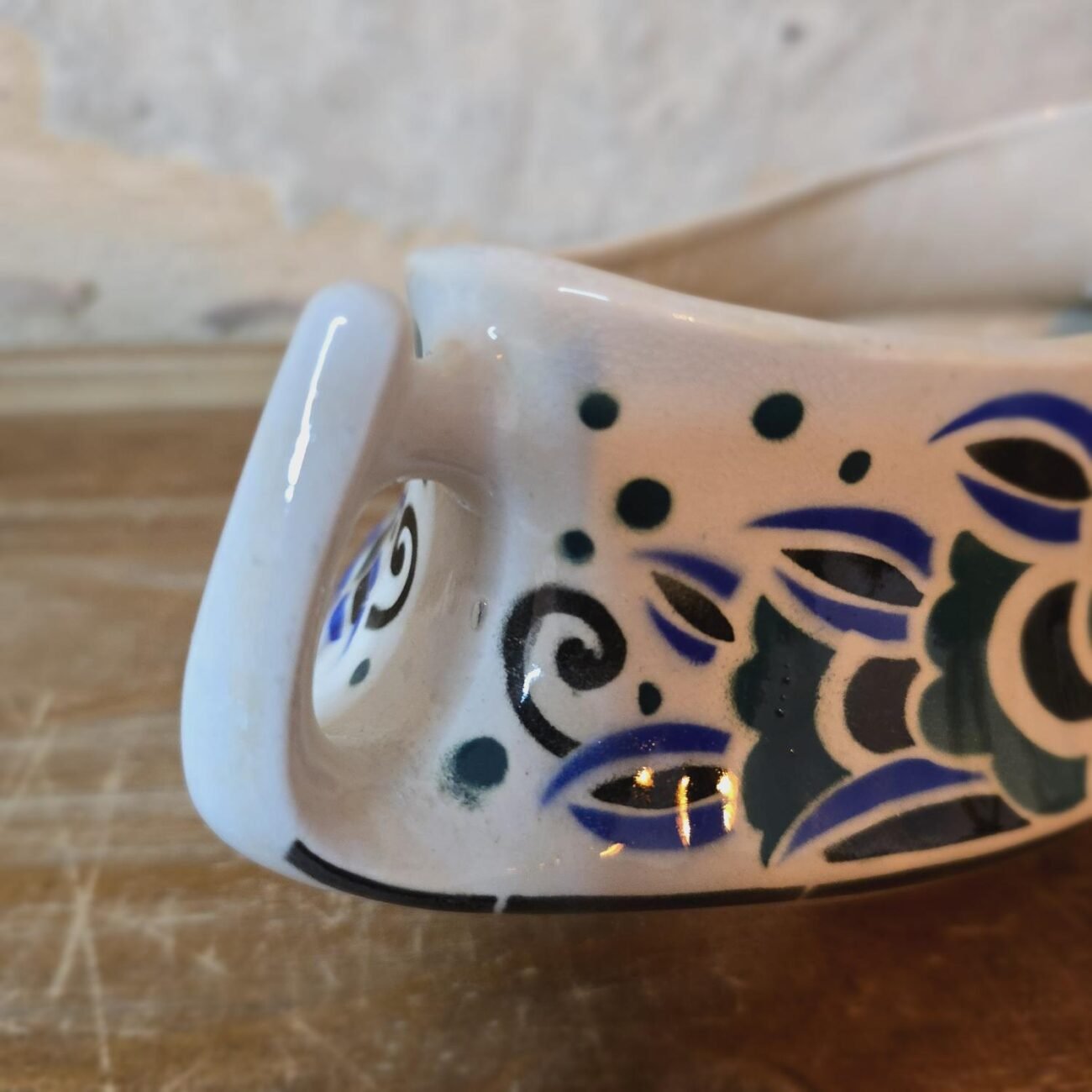 Motif floral sur fond crème, vue rapprochée du côté de la jardinière vintage.