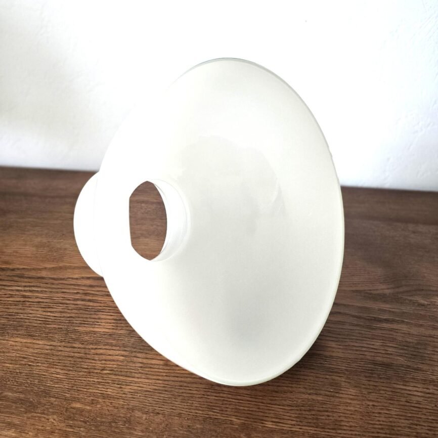 Vue de côté du globe opaline blanc vintage, soulignant ses lignes arrondies.