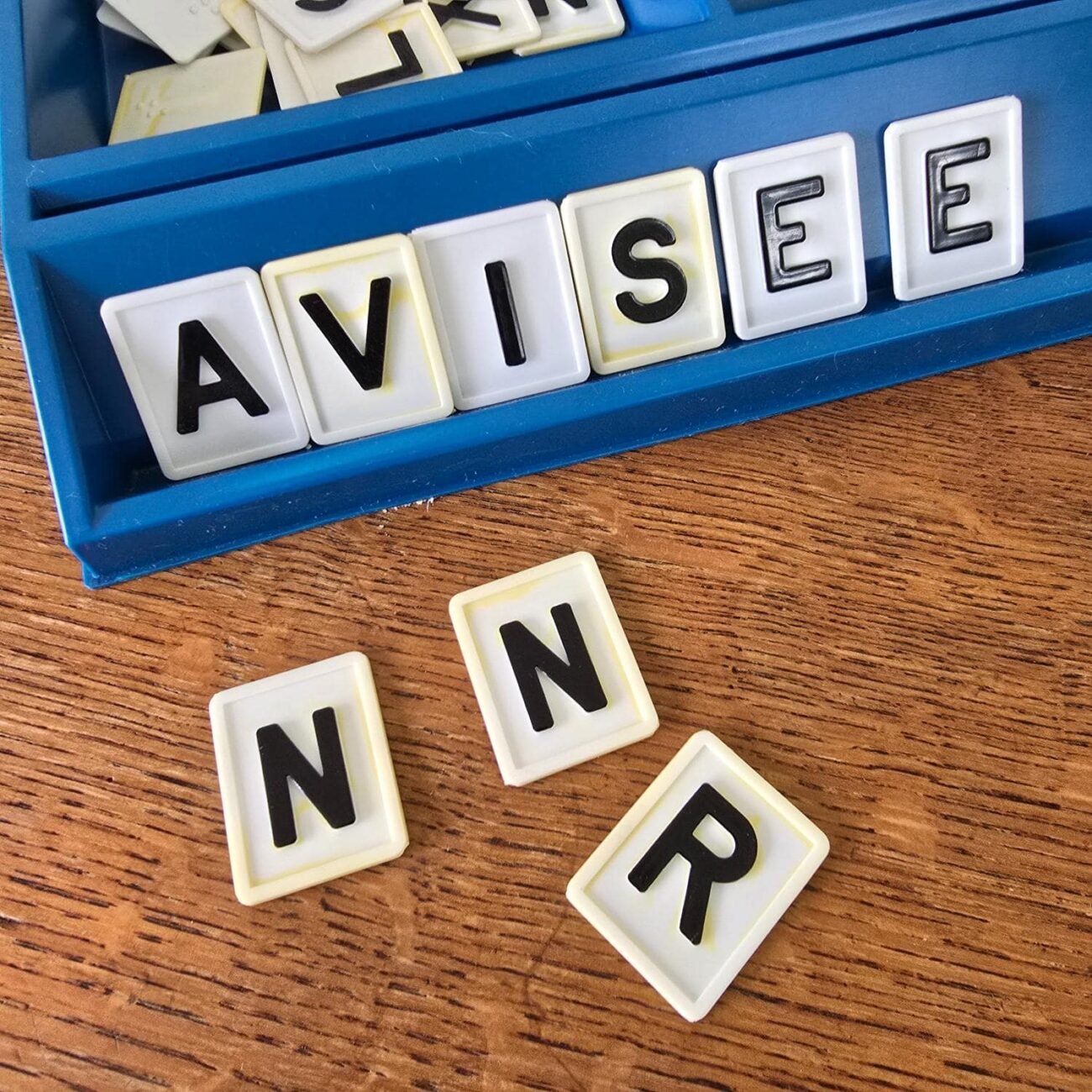 Zoom sur lettres 'AVISEE' du jeu Le mot le plus long, typographie rétro visible.