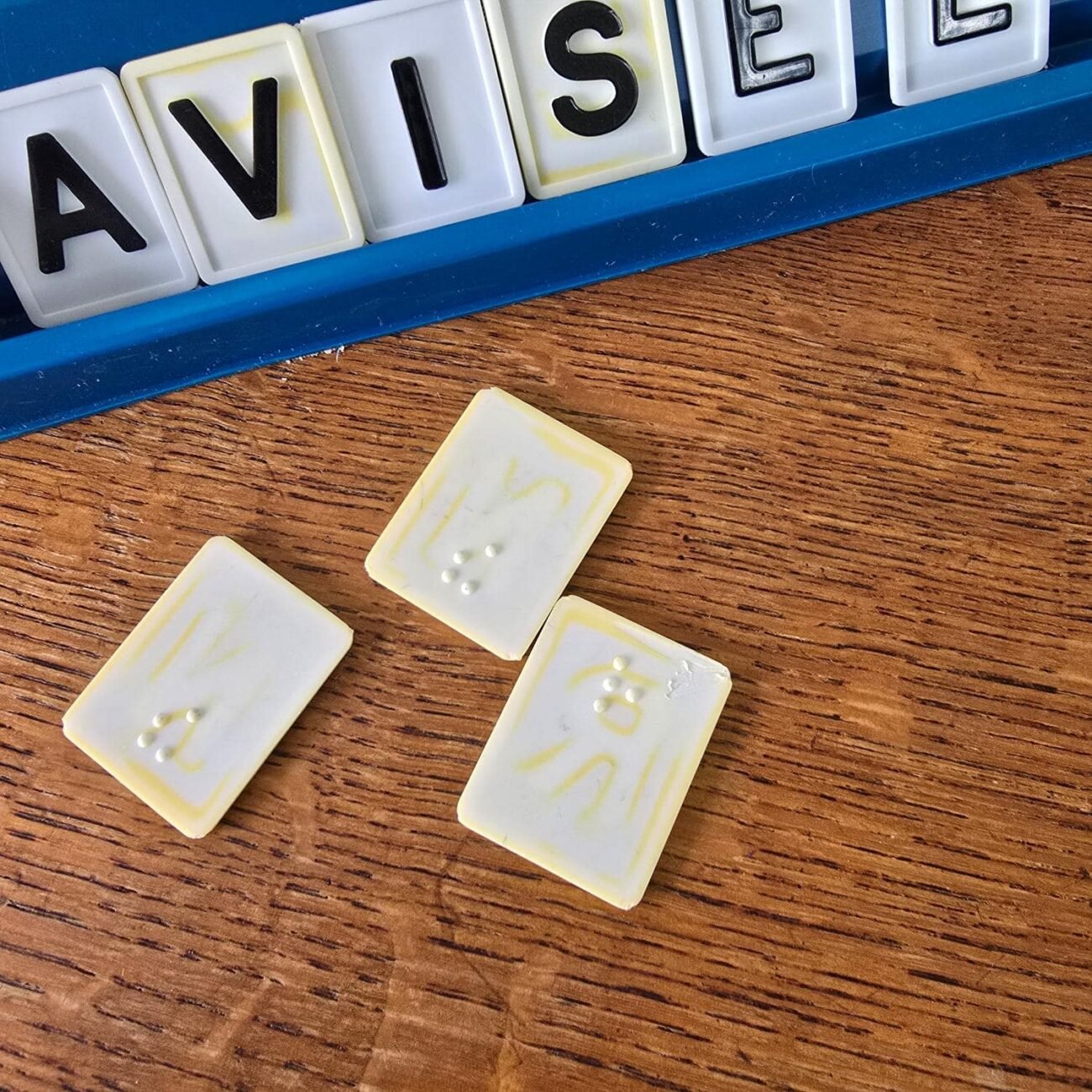 Jetons double-face : lettre d'un côté et équivalent en braille au dos.