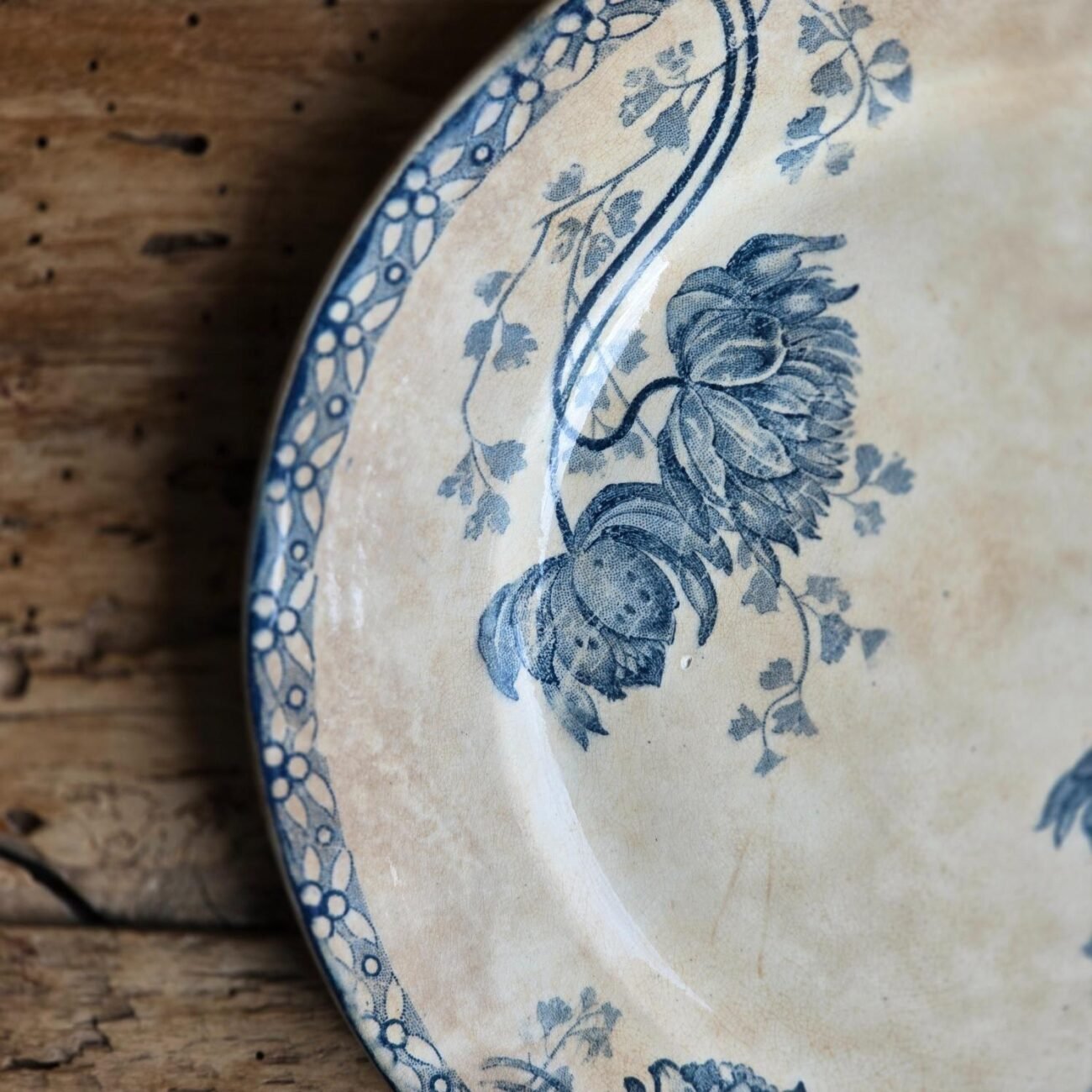 Détail du bord de l’assiette ROYAT – décor floral bleu et usure naturelle