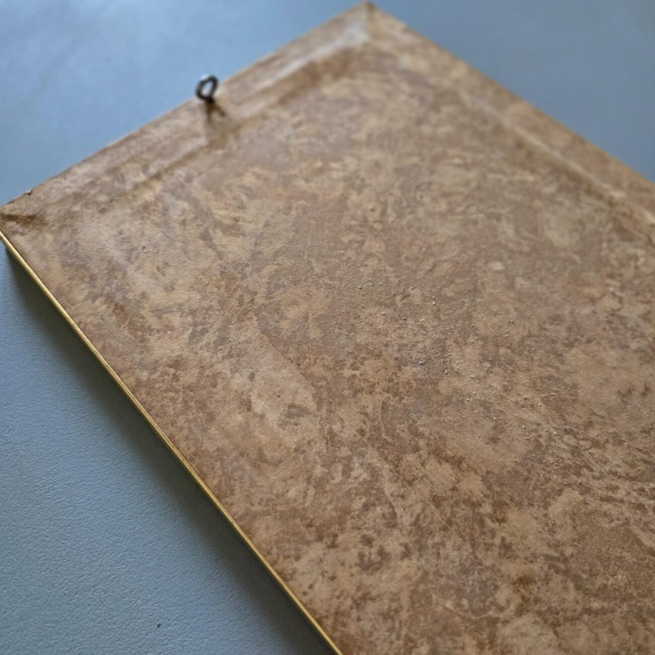 Dos du cadre montrant le système d’accroche et le papier d’origine marbré