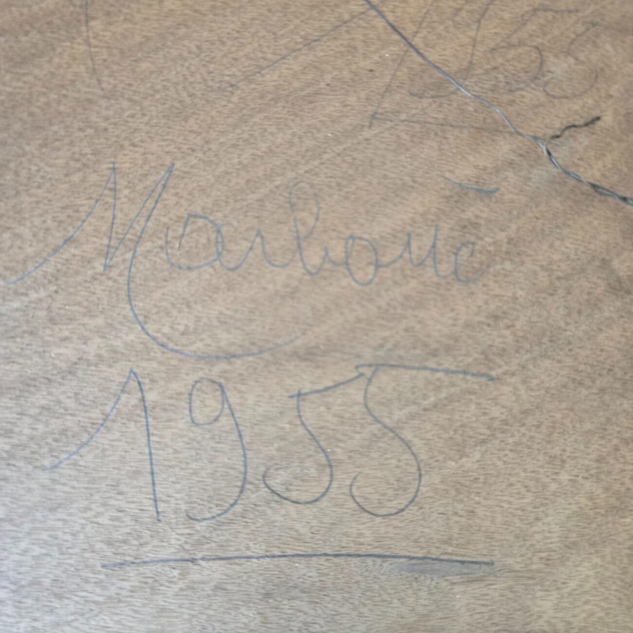 Zoom sur l’inscription manuscrite « 1955 » à l’arrière du cadre, écrite à même le bois.