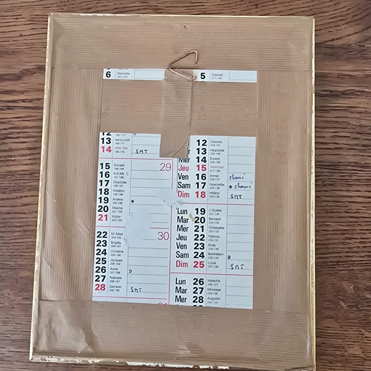 Dos du cadre doré avec calendrier d'époque utilisé comme support – attache métal visible