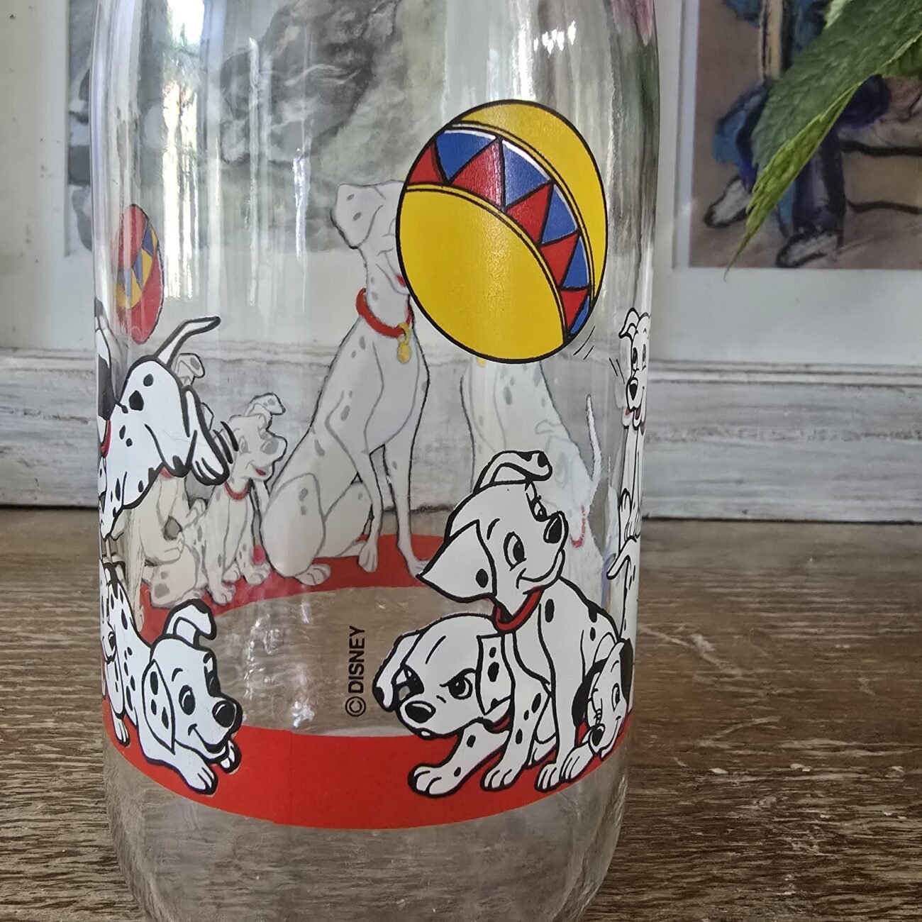Gros plan sur le décor de la carafe représentant des chiots dalmatiens autour d’une balle jaune à motifs rouges et bleus.