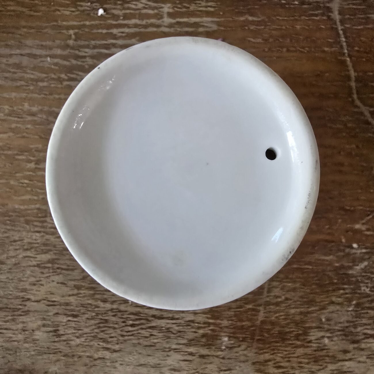 Vue de dessous du mug montrant le dessous blanc émaillé.