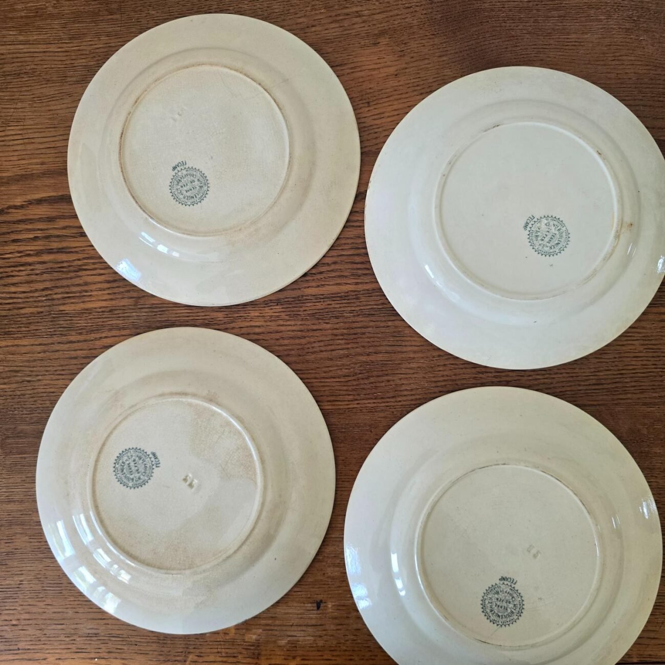 Vue de dos des 4 assiettes anciennes sur table en bois