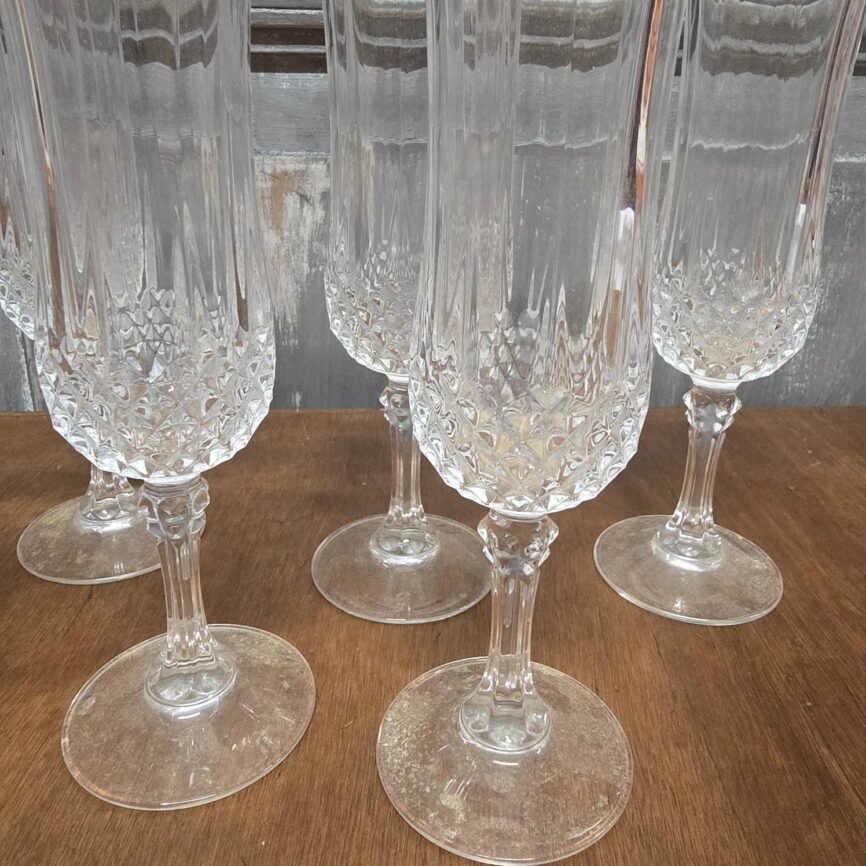 Flûte à champagne vintage en verre travaillé, vue rapprochée avec décor ciselé et pied nervuré.